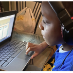 4th grade boy , headphones on looking at his computer screen
